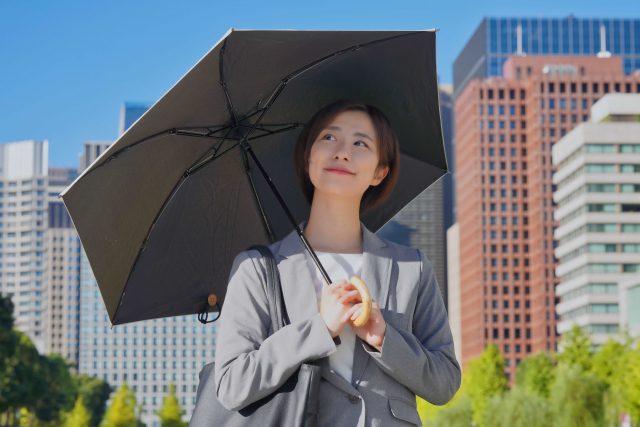 黒い日傘をさす女性
